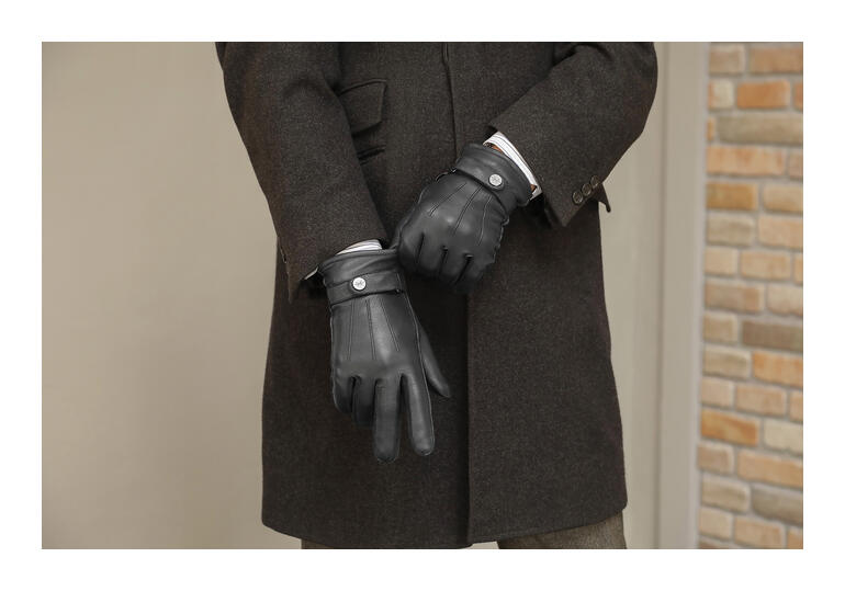 Schwarz Mann trägt schwarze Hirschleder-Handschuhe in einer eleganten Winterjacke.