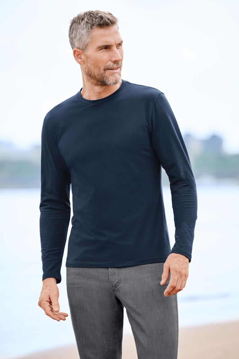 Herren, Navy Mann trägt Junghans 1954 Kaschmir-Longsleeve am Strand.