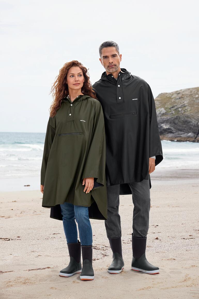 Regencape für Unisex von Tretorn, getragen von einem Mann und einer Frau am Strand.