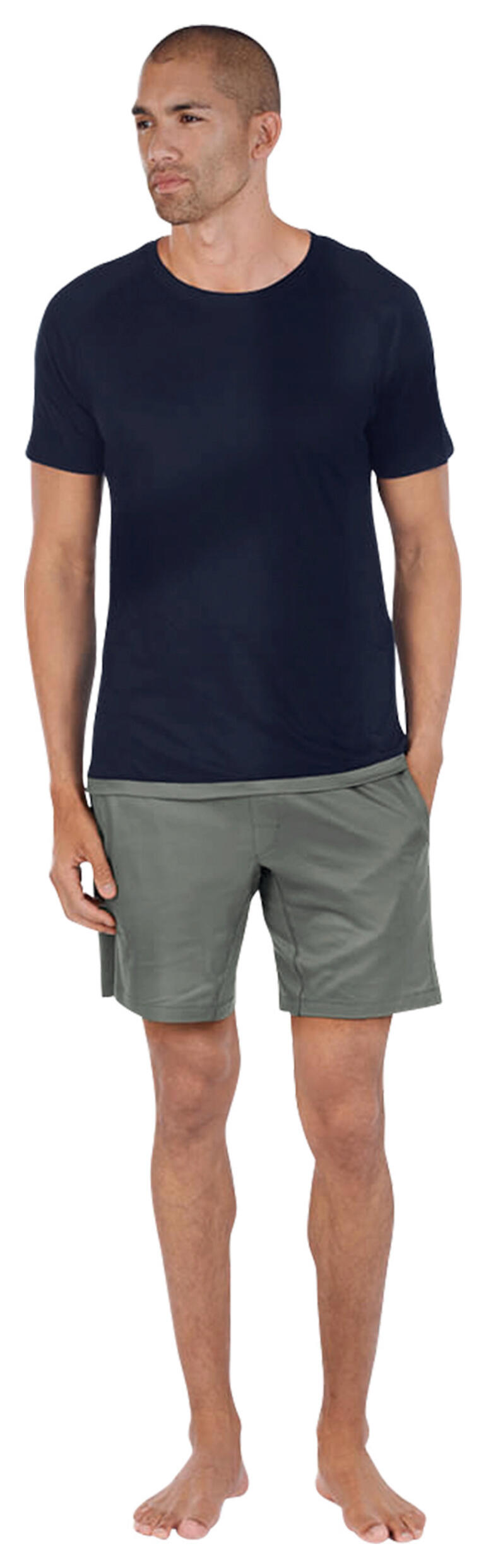 Navy/Salbei Mann in dunkelblauem Pyjama-Oberteil und grauen Shorts, steht barfuß.