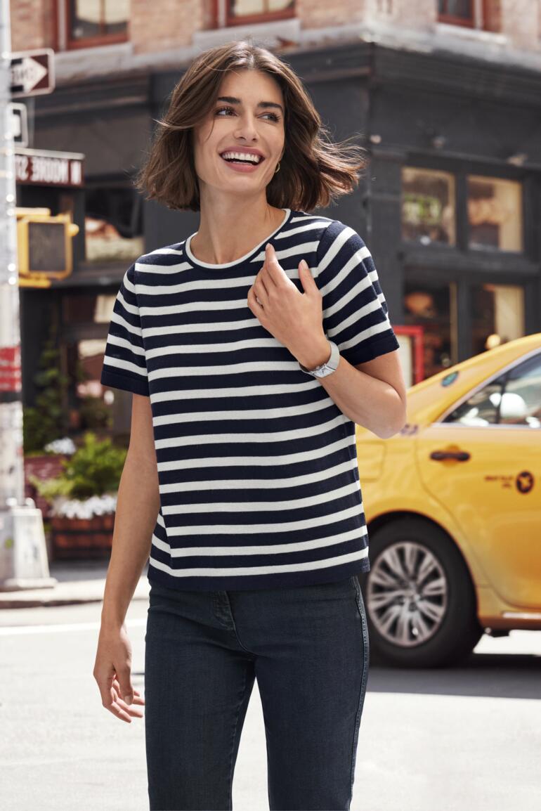 Frau trägt gestreiftes Merino-Ringelshirt und lächelt.