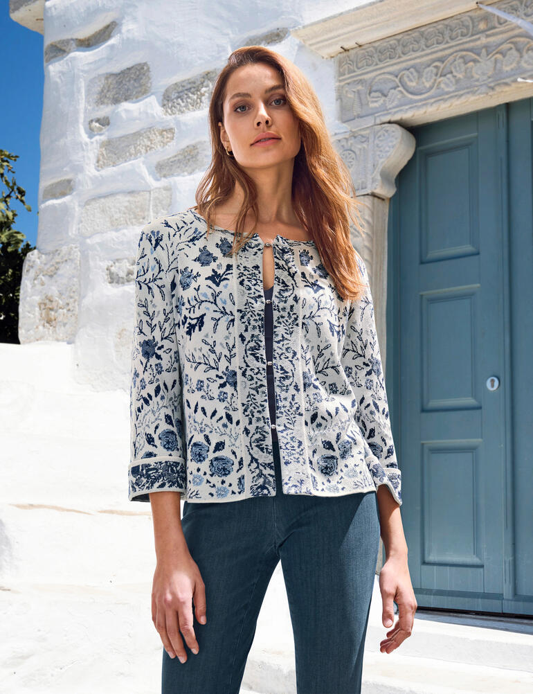 IVKO Floral-Cardigan Frau in floralem Cardigan vor einer weißen Wand.