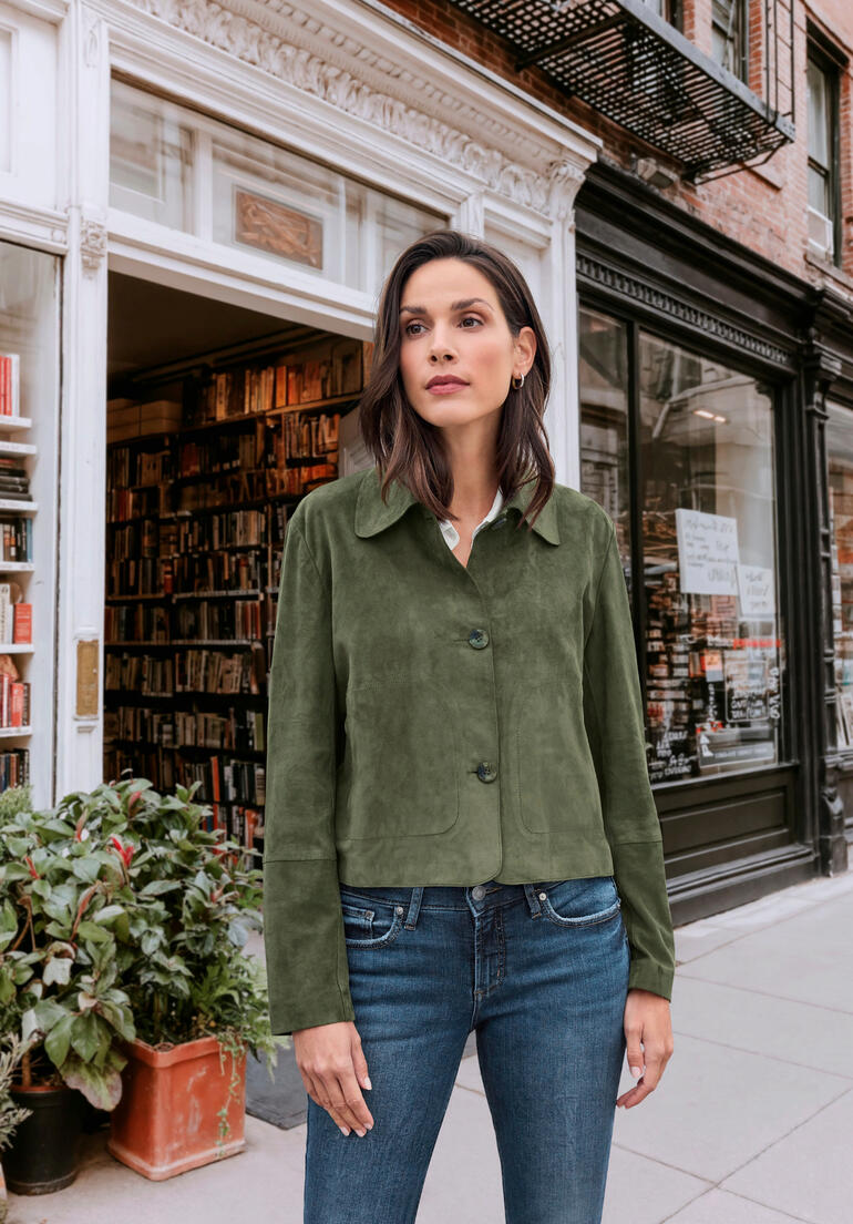 OCONI Ziegenvelours-Hemdjacke Frau in grüner Ziegenvelours-Hemdjacke vor Buchladen