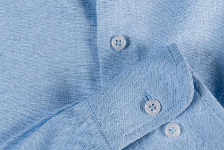 Blau Hellblaues Leinenhemd mit Knöpfen, Detailaufnahme.
