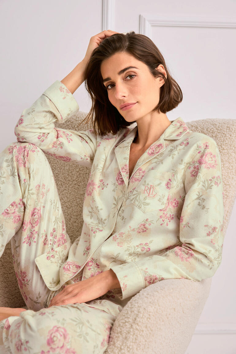 Ralph Lauren Blumen-Pyjama Frau in floralem Ralph Lauren Pyjama, sitzend und nachdenklich.