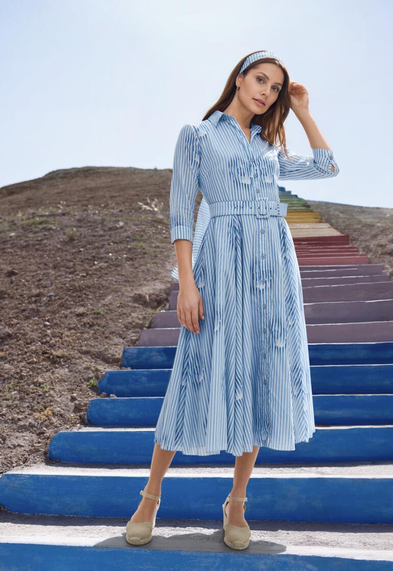 Blau gestreiftes Kleid mit Knopfverschluss und Gürtel, getragen von einer Frau.