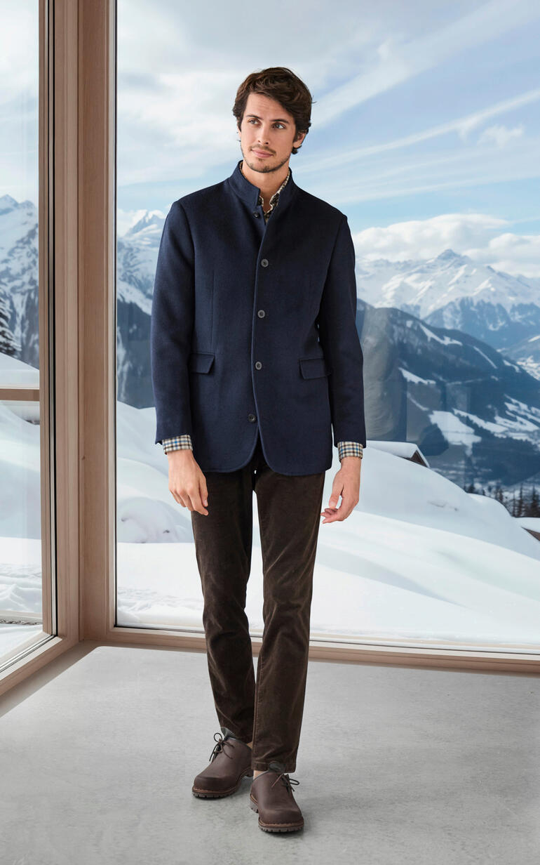 Mann im navy Baby-Alpaka-Sakko vor schneebedeckten Bergen