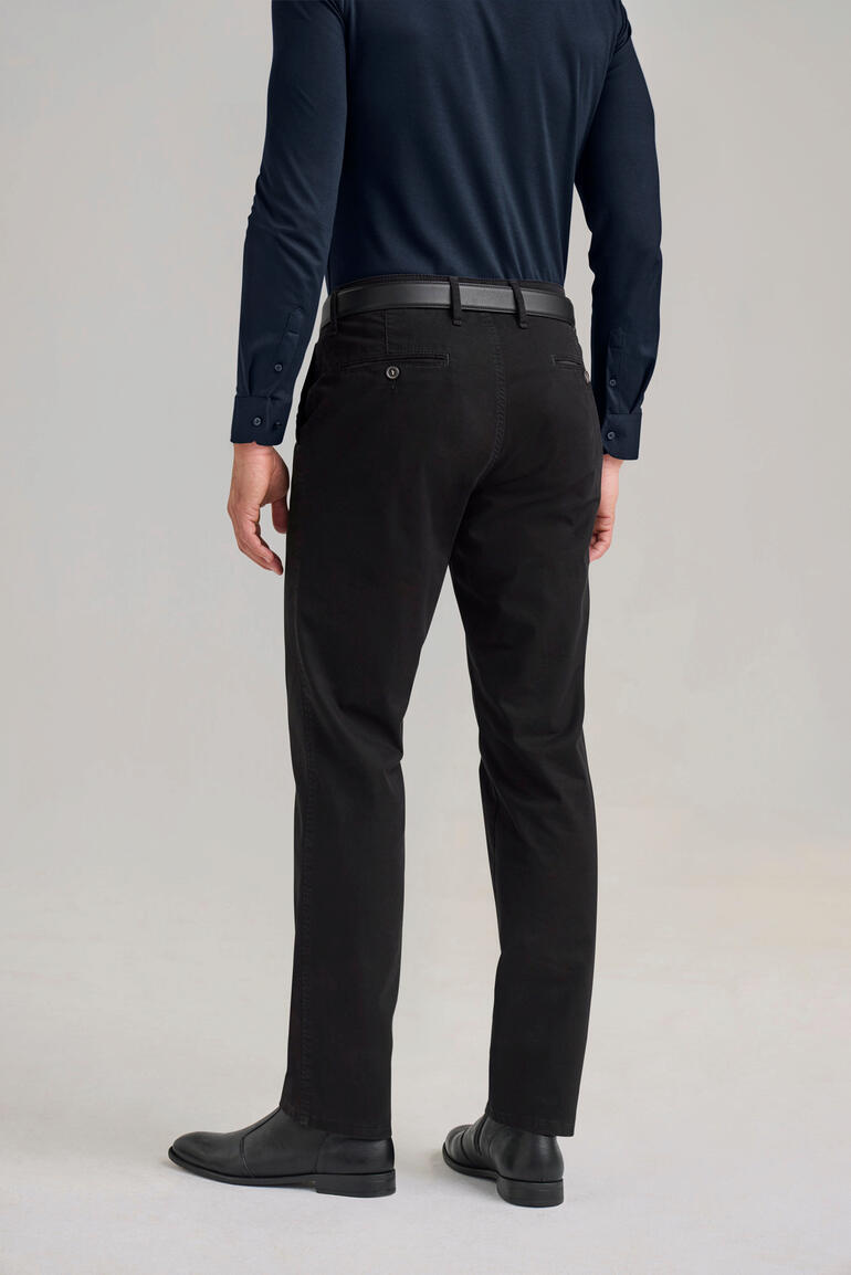 Perma-Black-Chino Mann trägt schwarze Perma-Black-Chinos, von hinten sichtbar.
