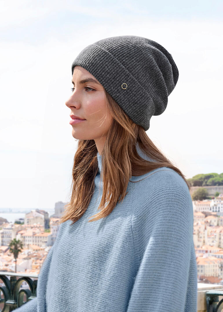 Dunkelgraue Kaschmir-Beanie getragen von einer Frau mit Blick auf die Stadt