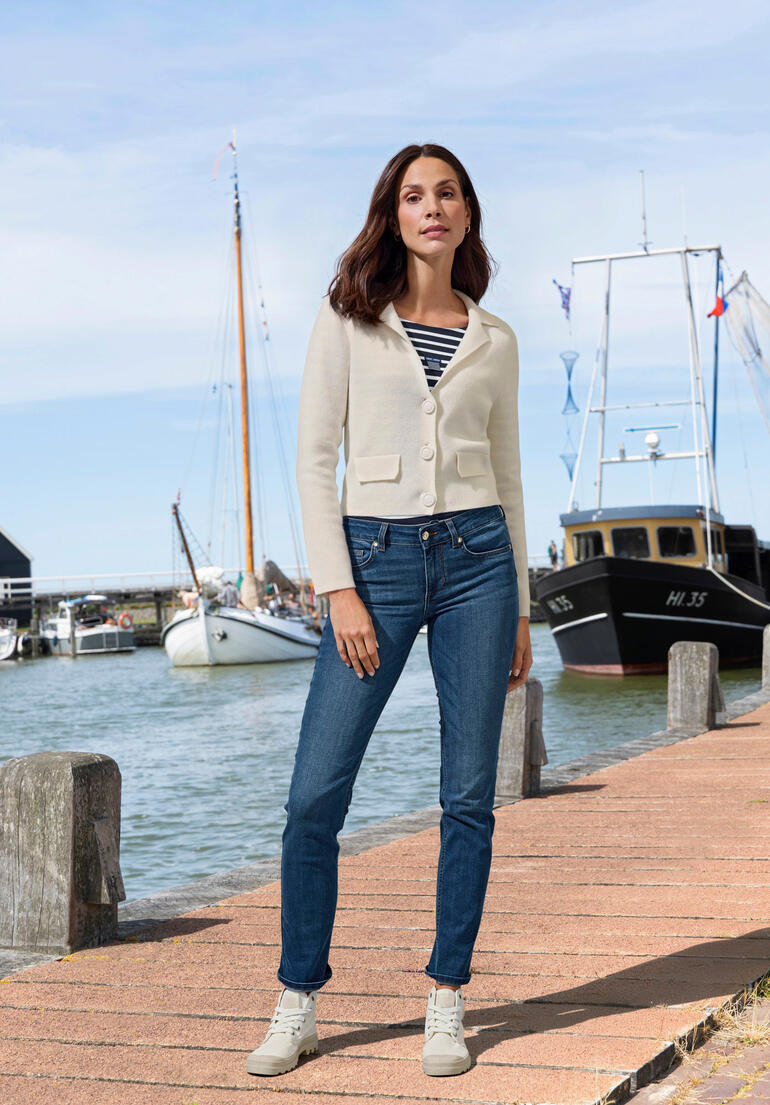 Frau in einem weißen Kaschmir-Blazer am Hafen