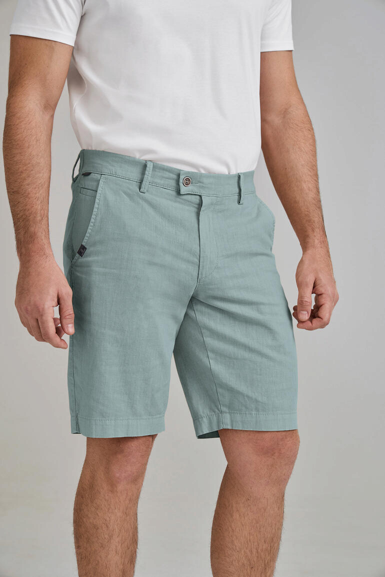 Mann in hellgrünen Business-Leinen-Bermudas im Stehen