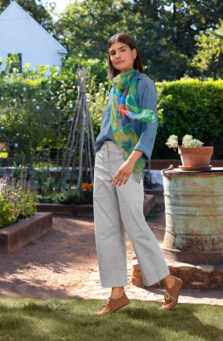 Seersucker-Streifenhose Bella Dahl Jeansbluse in Blau, getragen von einer Frau in einem Garten.