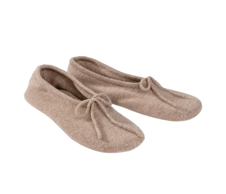 Zwei Kaschmir-Reisehausschuhe in hellem beige nebeneinander.