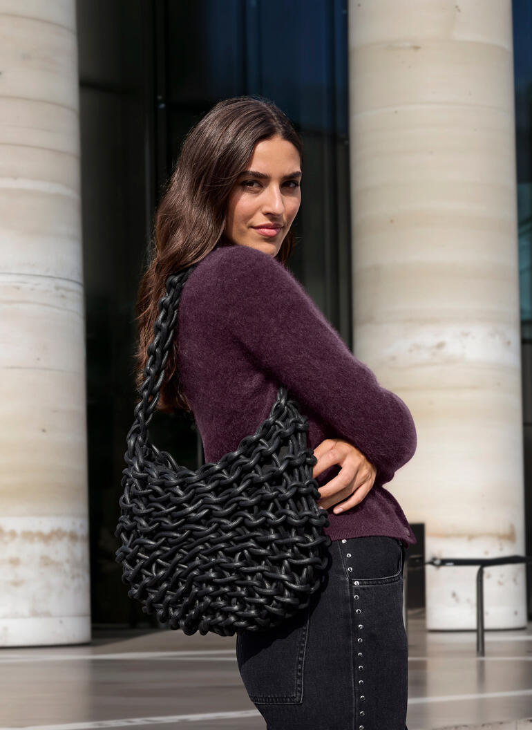 Frau trägt braunen JH1954 Cashmere-Cardigan und hält eine schwarze Tasche