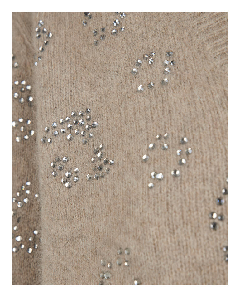 Detailaufnahme des braunen Pullovers mit glitzernden Mustern.
