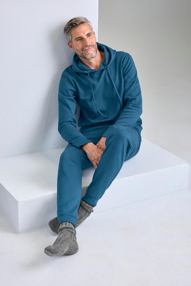 Mann in azurblauem Cashmere-Cotton-Loungewear-Anzug auf einer Sitzfläche