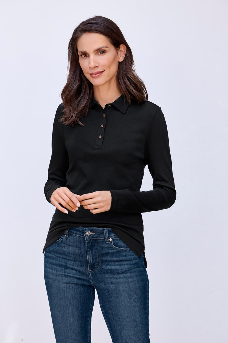 Frau trägt schwarzes Pima-Interlock-Polo mit Knöpfen.