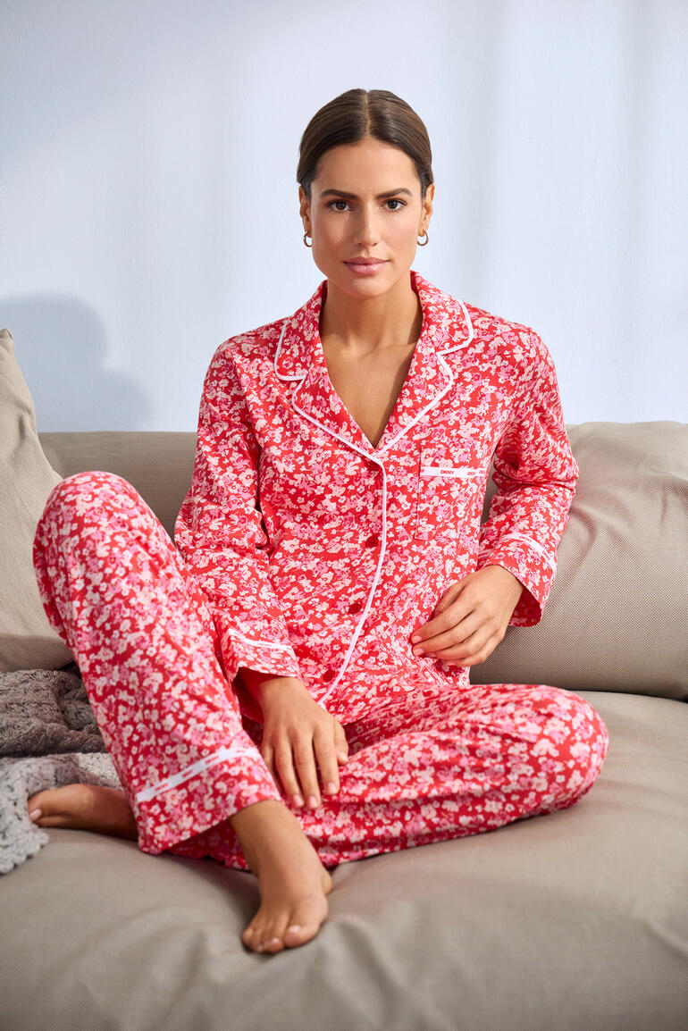 DKNY Pyjama mit Blumenmuster in Rot, Model sitzt auf der Couch.