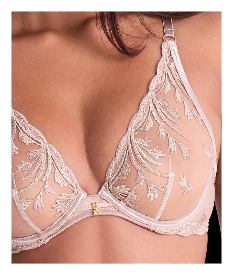 Detailaufnahme eines BHs mit zarten Stickereien in Sandfarbe.