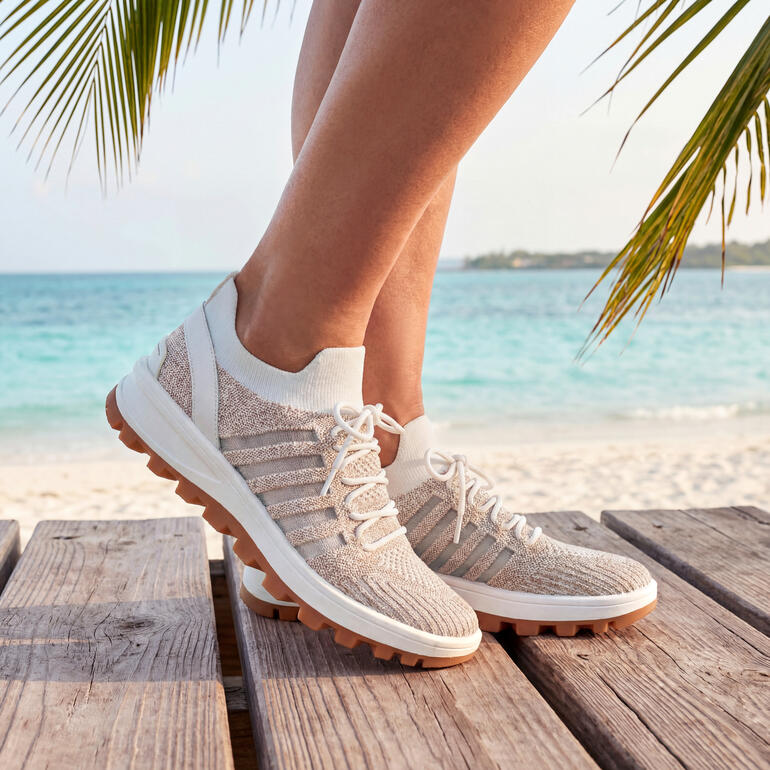 Füße in weißen Bernie Mev Knit Schnür-Sneakern, Größe 36, am Strand.