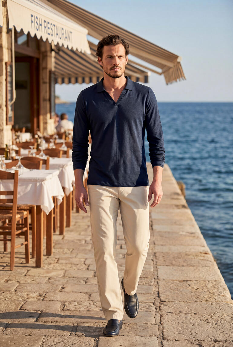 Mann in blauen Langarm-Shirt mit Holzdekor im Hintergrund.
