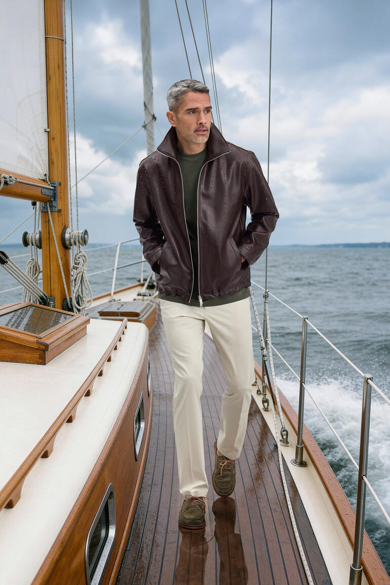 Mann trägt eine braune wetterfeste Kunstlederjacke auf einem Boot.