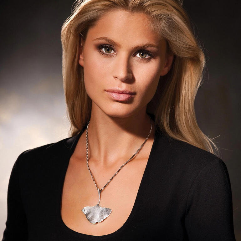 Silber Frau trägt eine silberne Ginkgo-Kette und schaut zur Seite.