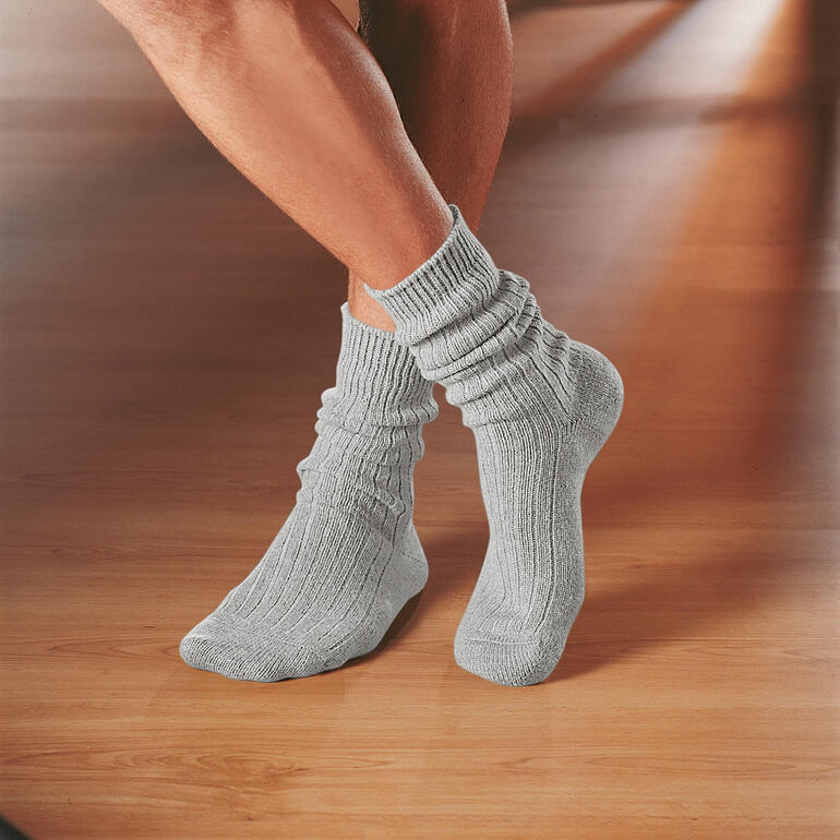 Graue Corgi-Kaschmir-Socken auf einem Holzboden.