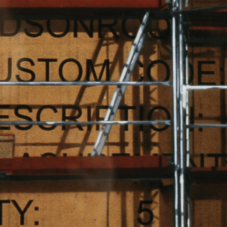 Detailaufnahme einer Baustelle mit Gerüst und Bauinformationen.