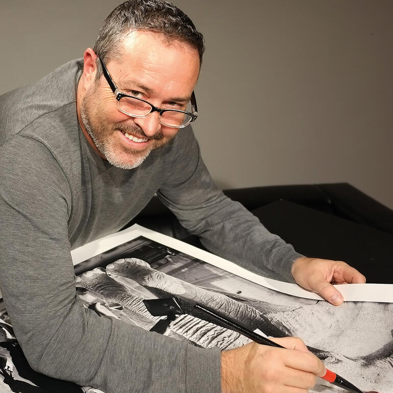 Lars Tunebo Künstler arbeitet an einem Fotodruck mit einem breiten Lächeln.
