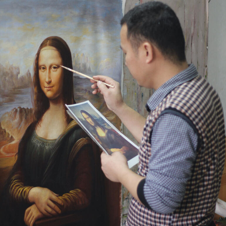 Hui Liu malt die Mona Lisa, während er auf das Original blickt.