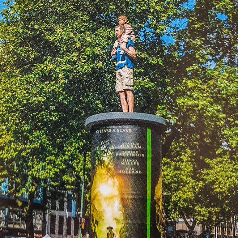 Die 1,90 m große Originalskulptur auf einer Litfass-Säule ist in der Düsseldorfer Innenstadt (Immermannstraße, Ecke Poststraße) zu sehen. Vater und Sohn-Skulptur auf einem Platz, umgeben von Bäumen.