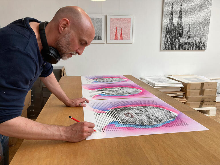 SAXA bei der Signatur. Künstler zeichnet an seinem Werk 'Sleep Well' in einem modernen Atelier.