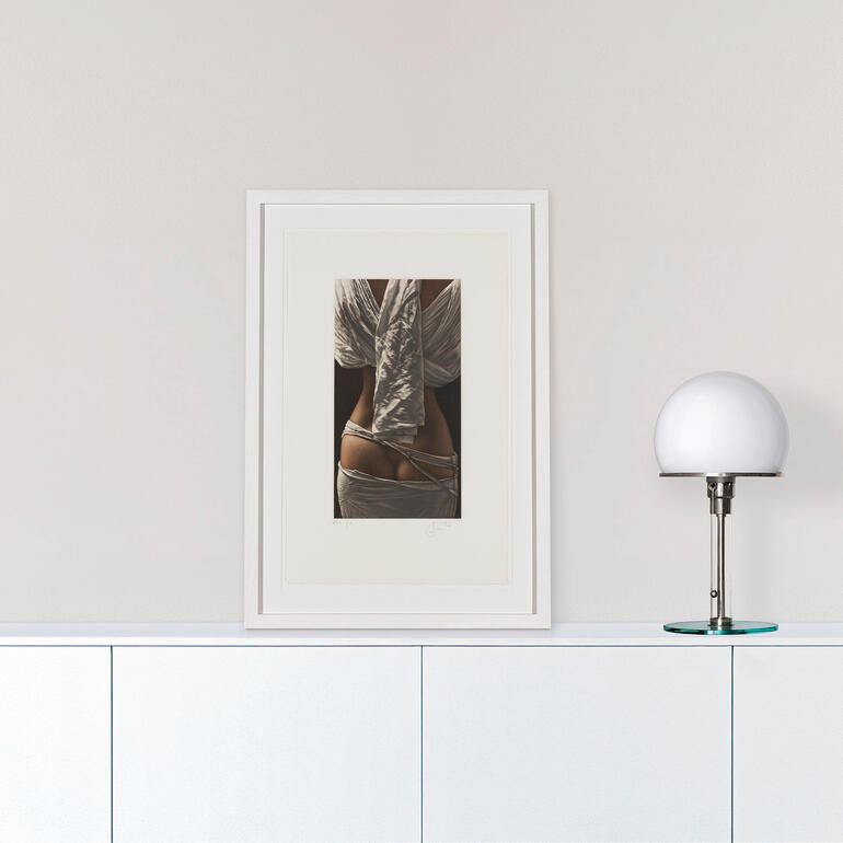 Kunstwerk, das an einer Wand hängt, neben einer modernen Lampe.