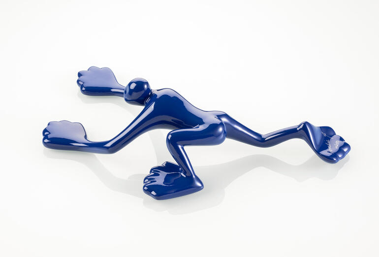 Dunkelblaue Skulptur in Form eines Frosches.
