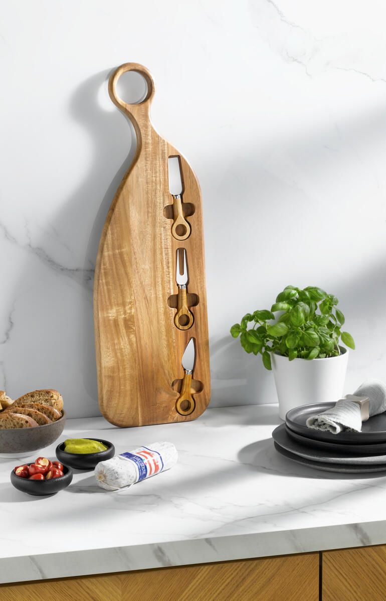 Design-Servierbrett aus Akazienholz mit Kochutensilien.