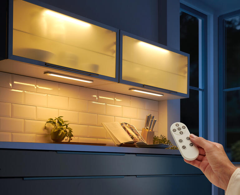 Akku-Lichtleiste mit Fernbedienung über einer Küchenzeile.