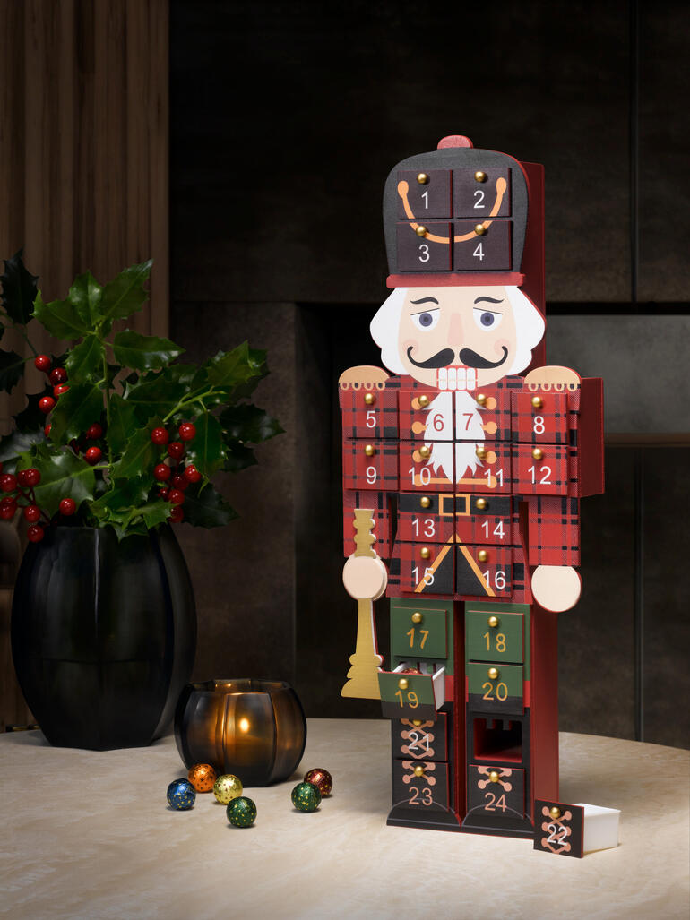 Adventskalender in Form eines Nussknackers, dekoriert mit nummerierten Türchen.