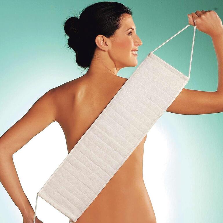 Sanft und schonend reinigen Sie jetzt auch schwer zugängliche Körperzonen. Frau hält ein langes Micro Peeling Handtuch über ihrer Schulter.