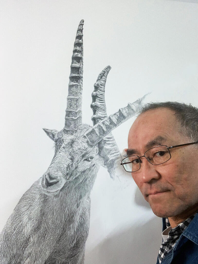 Koshi Takagi Mann hält Skizze von Steinbock, selbstporträt im Hintergrund.