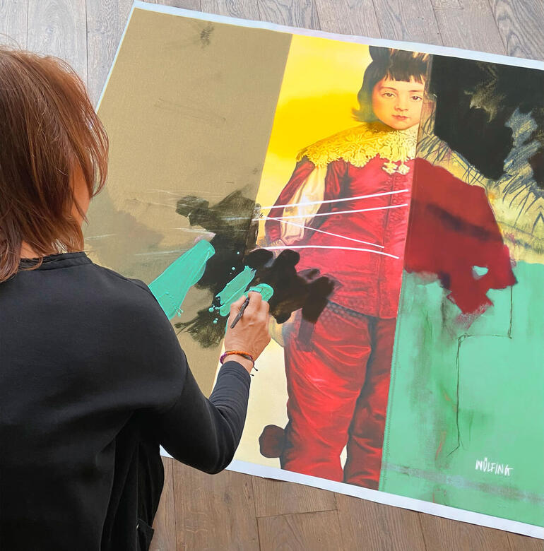 Frau malt an einem Kunstwerk mit lebendigen Farben.