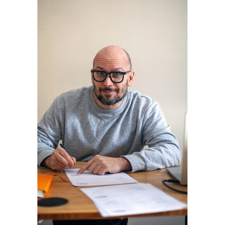 Robin Cerutti Robin Cerutti sitzt an einem Tisch und arbeitet an Unterlagen.
