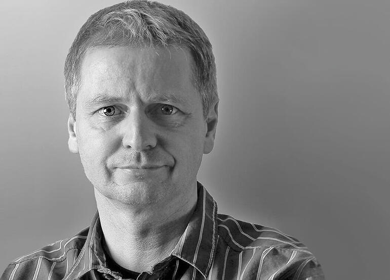 Andreas Lutherer posiert in einem Porträtfoto mit neutralem Gesichtsausdruck.