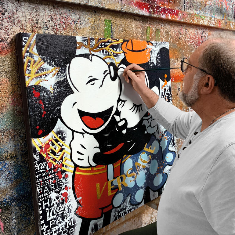 Devin Miles malt ein Kunstwerk mit Mickey Mouse und Versace-Motiv.