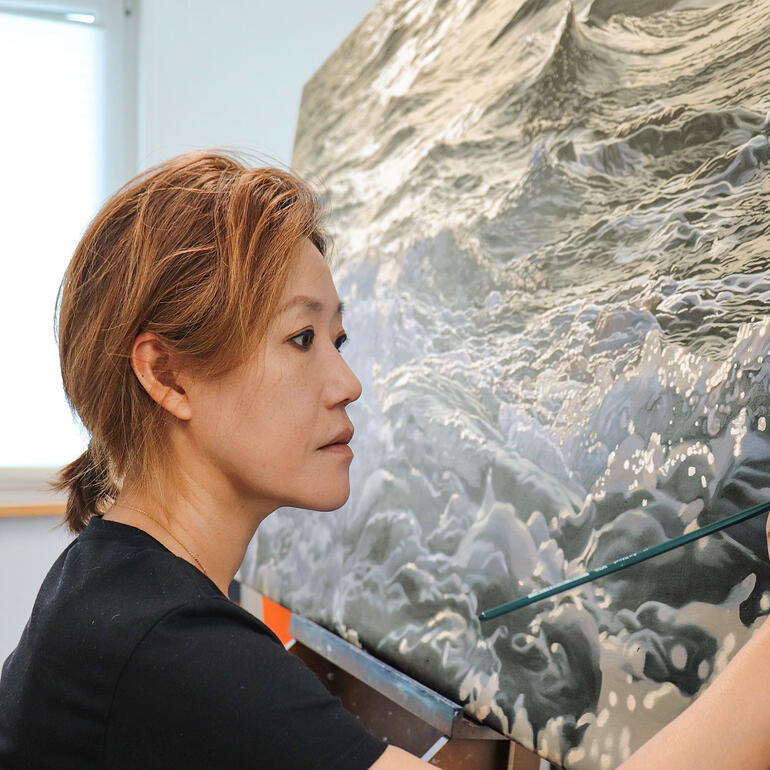 Eun Jung Seo-Zimmermann malt an einer großformatigen Welle.