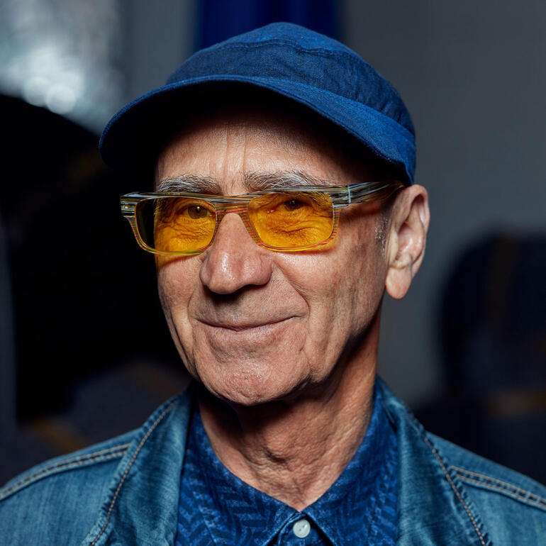 Thomas Schönauer lächelt in einer klaren Brille in einem blauen Hemd.